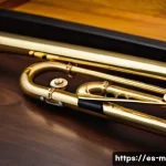 Home 20 트럼펫과 트롬본 차이 - A detailed close-up of a classical trombone resting on a dark wooden surface, highlighting its large...